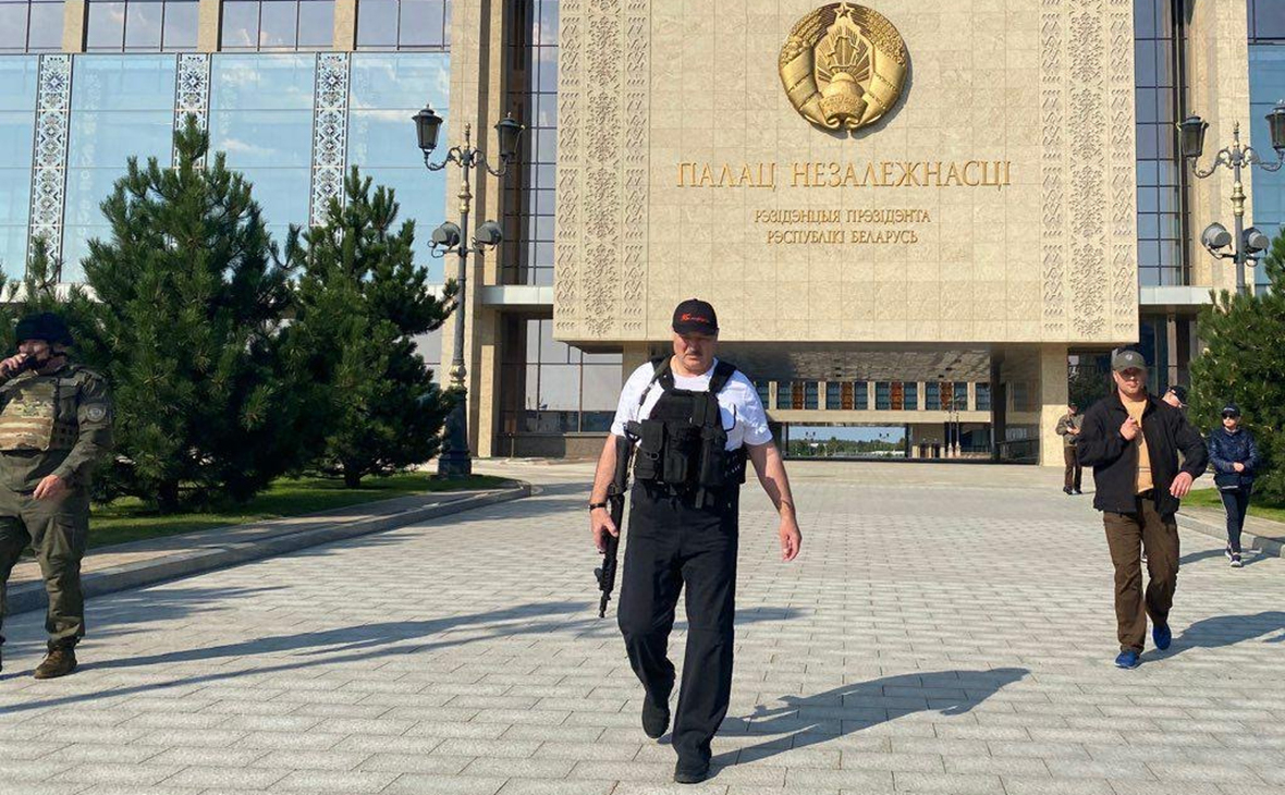 Лукашенко идет с автоматом на фоне Дворца Независимости в Минске во время протестов в августе 2020 года
